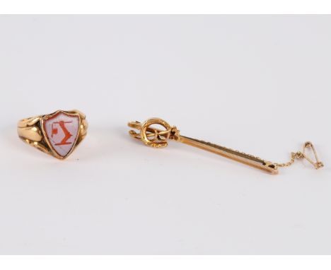 A hardstone signet ring, the shield shaped intaglio carved matrix set in 18ct yellow gold, size O and a 9ct gold brooch with 