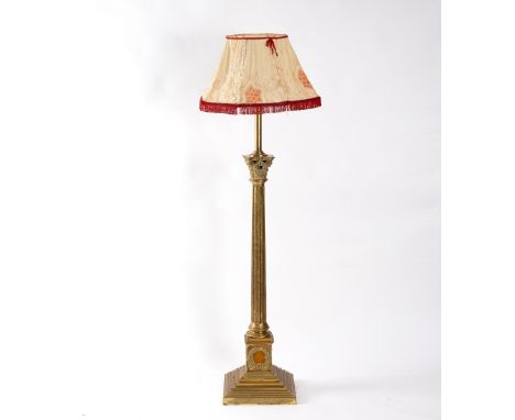 A Victorian brass standard lamp converted from an oil lamp, of Corinthian column form on a stepped base