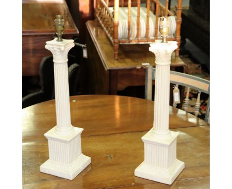 A pair of pottery table lamp bases of Corinthian column form, the fluted columns on square plinths, 54cm high
