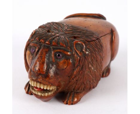 A coquilla nut lion snuff box, circa 1800, realistically carved with bone, teeth and tongue, the back hinged to form a box, 7