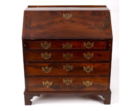 A George III mahogany bureau, circa 1760, the hinged fall concealing an interior with central starburst cupboard flanked by s