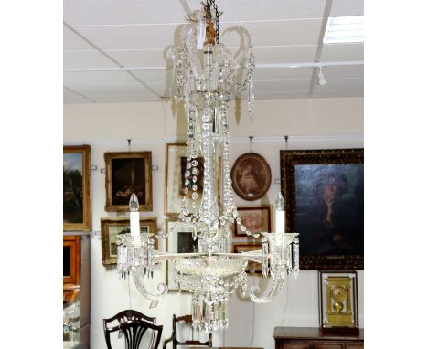 An Osler style cut glass three-light chandelier with scroll and foliate crown, the central baluster column set three cornucop