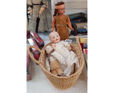 2 antique baby dolls in a vintage basket store