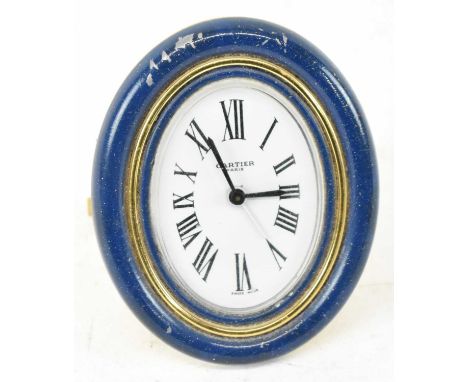 CARTIER; a gilt metal and lapis lazuli effect travelling easel back clock, the white enamel oval dial set with Roman numerals