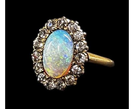 A 14ct yellow gold opal and diamond ring, set with large central opal surrounded by fifteen small diamonds, size L, approx 4.