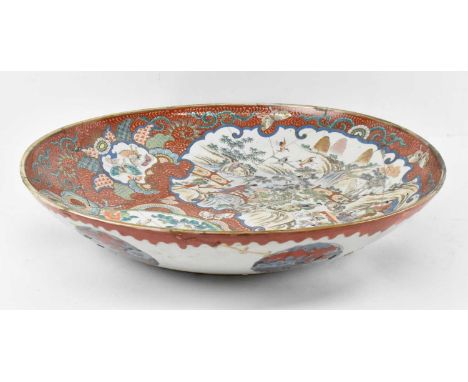 A 19th century Japanese Imari decorated bowl with panels of hand painted figures on a red ground, diameter 62cm (af).Conditio