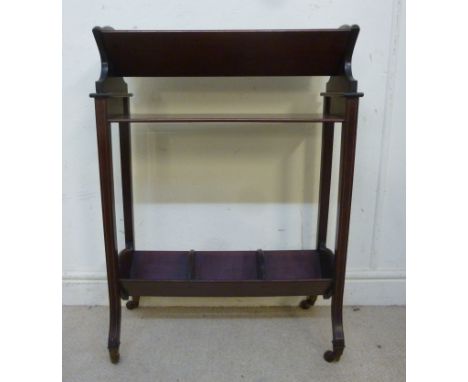 An Edwardian string inlaid mahogany and marquetry two tier book trough, having shaped ends and a shelf raised on square, spla