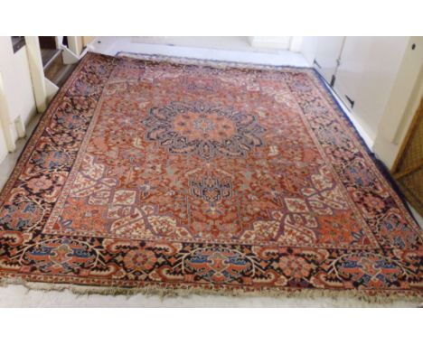 A Persian carpet with a central medallion, boteh, palmettes and angular flowers on a red ground  123'' x 166''