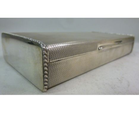 A South American silver coloured metal cigarette box, having straight sides, the hinged lid with cast and engine turned ornam