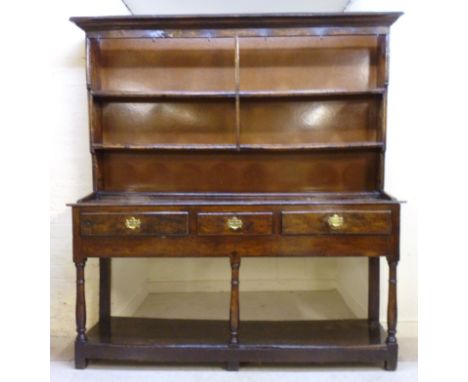 A George II oak dresser, having a moulded cornice, over three shelves, the base having three in-line drawers and deep frieze,