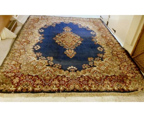 A Persian carpet with a central floral medallion and quadrants on a blue ground  116'' x 160''