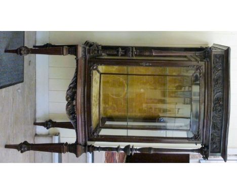 A late Victorian floral and foliate, bead carved, serpentine outlined display cabinet, having a shelf top, over a fully glaze