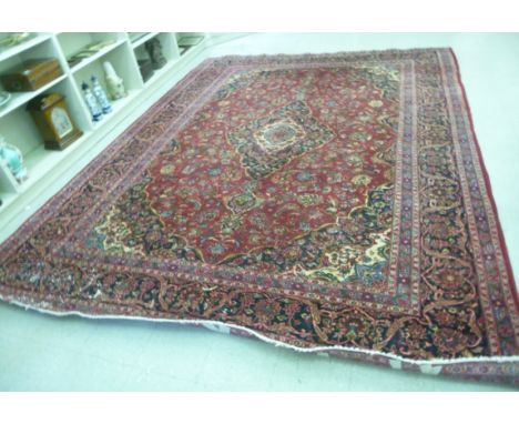 A Persian carpet with a central medallion, palmettes, flowers and foliage on a red ground  115'' x 160''