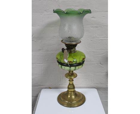 A brass oil lamp with etched shade and painted reservoir CONDITION REPORT: Several small nicks to the base of the glass shade