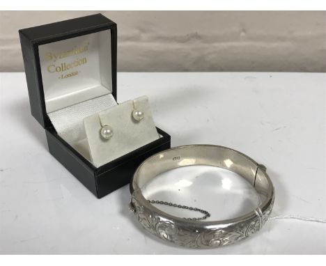 A pair of 9ct gold cultured pearl earrings, another pair of pearl earrings and a silver bangle