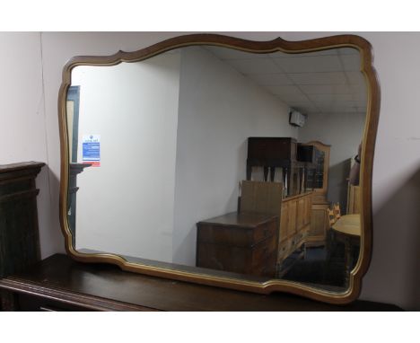 A shaped walnut framed overmantel mirror 
