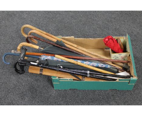 A box of walking stick with silver pommel, assorted sticks, parasols, clothes brushes etc  