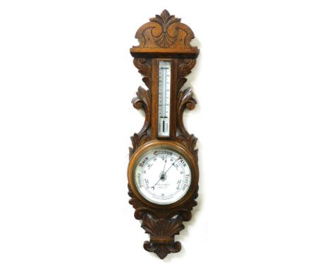 A Victorian oak cased aneroid barometer by Thomas Wallace and Company Limited, Holborn Circus, London, with thermometer, the 