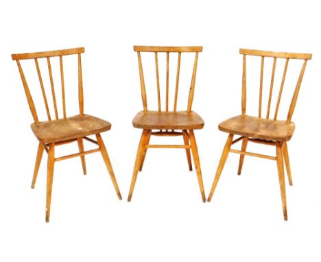 A set of three Ercol ash and elm stick back chairs, each with a solid seat on turned legs with stretchers, impressed mark to 