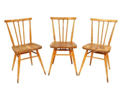 A set of three Ercol ash and elm stick back chairs, each with a solid seat on turned legs with stretchers, impressed mark to 