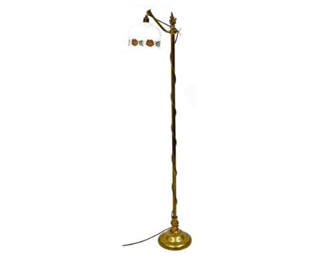 An early 20thC brass standard lamp, the adjustable arm with shade, printed with design of poppies, the column headed by a fla