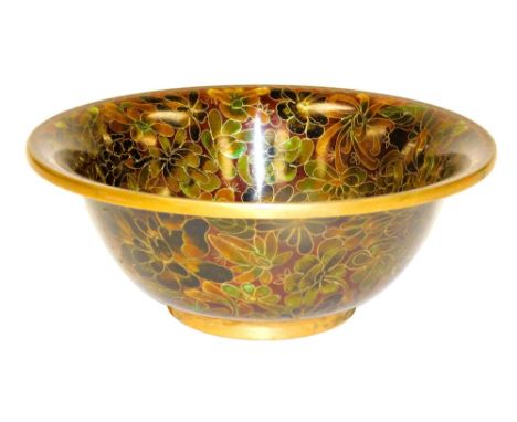 A Chinese cloisonne enamel bowl, decorated with flowers against a red ground, 18cm wide.
