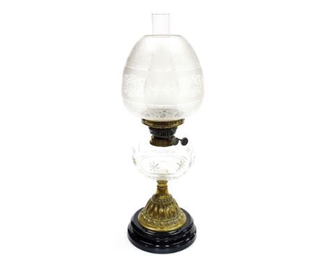 A late 19thC cut glass and brass oil lamp, with a clear and opaque floral etched shade, clear cut glass central reservoir, ra