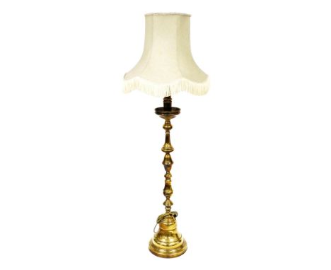 A turned brass standard lamp, with cream coloured shade with fringe borders, on a domed foot, 171cm high overall.