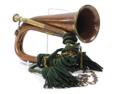 An early 20thC brass and copper military bugle, by G Potts and Company of Aldershot, 27cm wide.