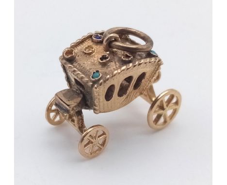 A 14 K yellow gold charm in the form of a carriage with moving wheels! Weight: 4 g. 