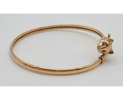 A 9K Yellow Gold Bangle with Cat-Head Clasp. Ruby eye decoration. 7.8g. 