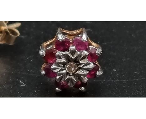 A 9 K yellow gold pair of stud earrings with rubies and diamonds. Total weight: 1.4 g. 