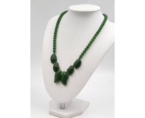A Beautiful Jade Pea-Green Bead and Graduated Leaf Necklace. 44cm. Comes in a presentation case. 