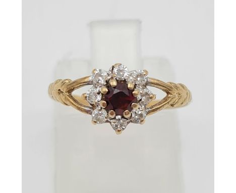 A 9 K yellow gold garnet and diamonds ring. Ring size L, weight: 1g. 