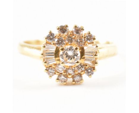 A hallmarked 18ct gold and diamond cluster ring. The ring being set with a central round brilliant cut diamond to the centre,