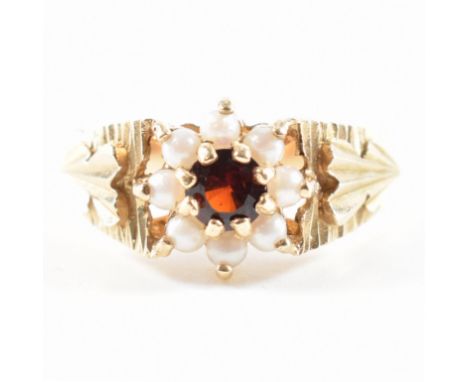 A hallmarked 9ct yellow gold, red stone &amp; pearl halo ring. The ring having a central round cut red stone surrounded by a 