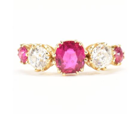 An 18ct gold, ruby &amp; diamond five stone ring. The ring having a central round cut ruby to the centre flanked by graduatin