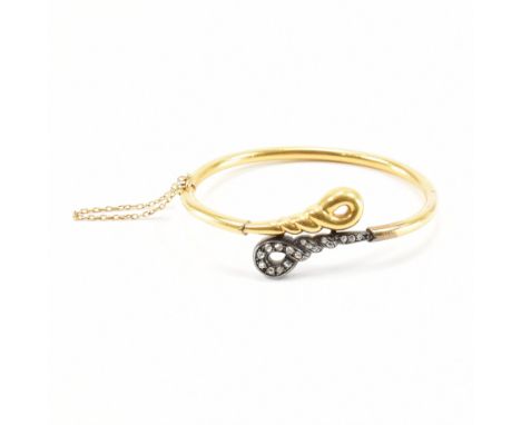 A continental Art Deco 18ct gold and diamond hinged bangle. The bangle having bi colour twist finials, one being set with ros