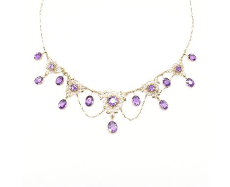 An early 20th Century Liberty &amp; Co Art Nouveau gold and amethyst set necklace having a fine link chain with sixteen round