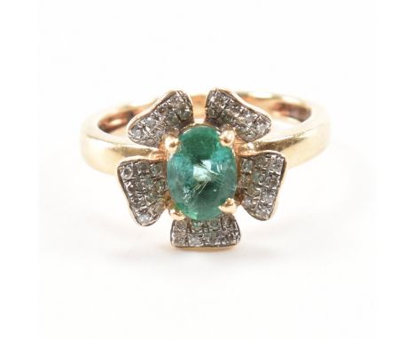 A gold emerald and diamond cluster ring. The ring in the form of a flower having a head set with an oval cut emerald with dia