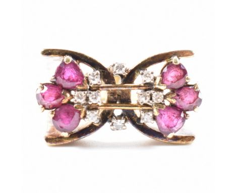 A vintage gold ruby and diamond ring. The ring having an X shaped head with split shoulders, set with six pear cut rubies and