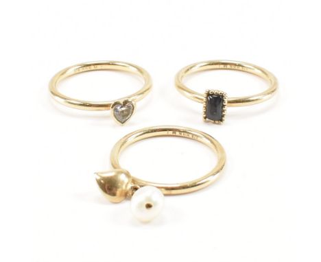 A group of three 9ct yellow gold stone set stacking rings. The first ring having a rectangular cabochon of grey chatoyant sto