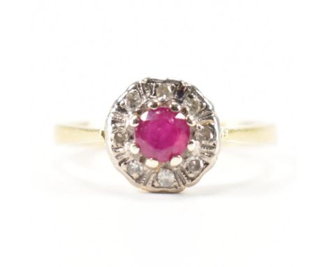 A hallmarked 18ct gold ruby and diamond halo ring. The ring being set with a central round cut ruby with eight round cut diam