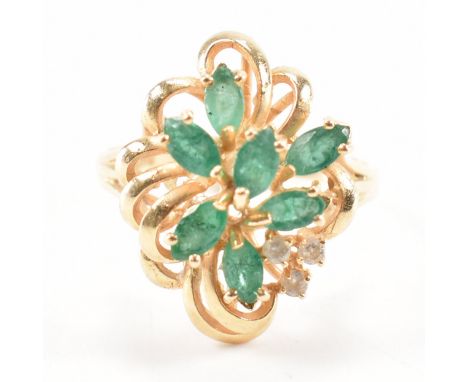 A 14ct gold emerald and diamond cluster ring. The ring set with seven marquise cut emerald with three round brilliant cut dia