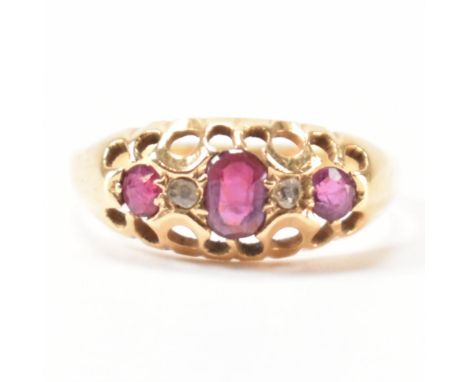 A hallmarked 18ct gold, ruby and diamond ring. The ring being set with a central oval cut ruby, flanked by two round cut diam