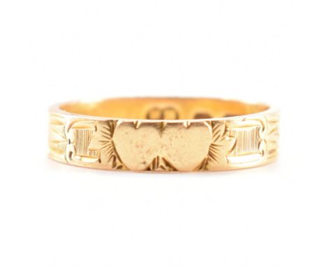 A hallmarked 18ct yellow gold twin heart ring. The ring having two hearts etched to the centre with further etched design thr