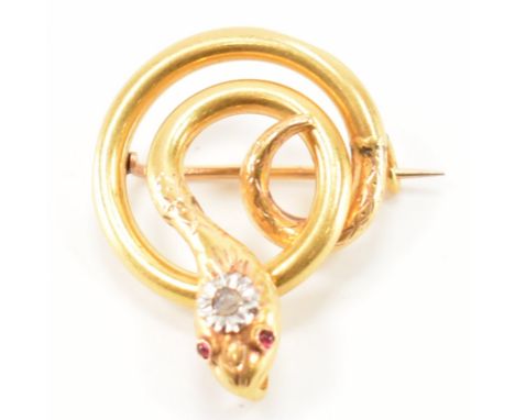 A 19th Century Victorian gold snake brooch. The brooch of coiled form having an illusion set diamond to the head with ruby se