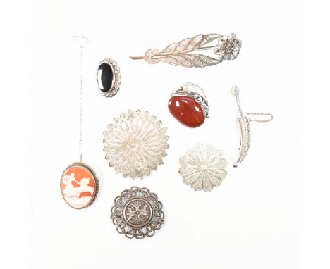 An assorted collection of silver brooch pins. The lot to include; three floral / flower design filigree wire work brooches, c