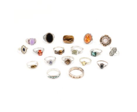 An assorted collection of silver stone set rings. The lot to include; black stone cabochon split shoulders ring, turquoise co