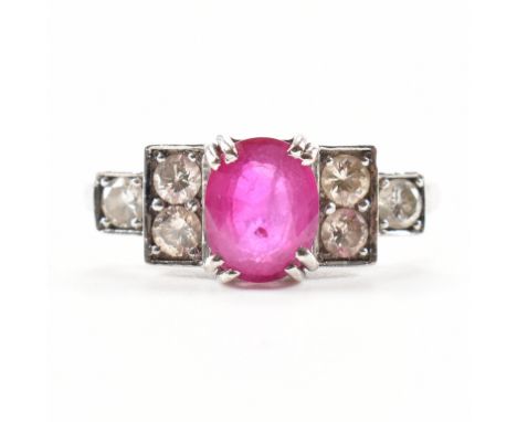 An 18ct white gold ruby and diamond&nbsp; Art Deco ring. The ring set with an oval mixed cut ruby flanked by terraced set rou